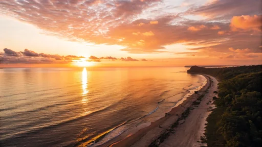Imagem de um nascer do sol tranquilo sobre o oceano, com luz dourada e atmosfera pacífica.
