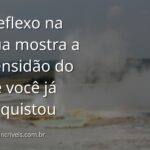 Vasto lago espelhando um céu azul com nuvens, evocando um sentimento de paz, amplitude e realização pessoal.