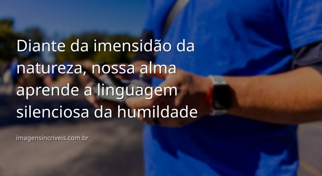 Céu vasto com nuvens suaves refletido sobre a superfície calma de um lago, com montanhas ao fundo, evocando um sentimento de paz e humildade.