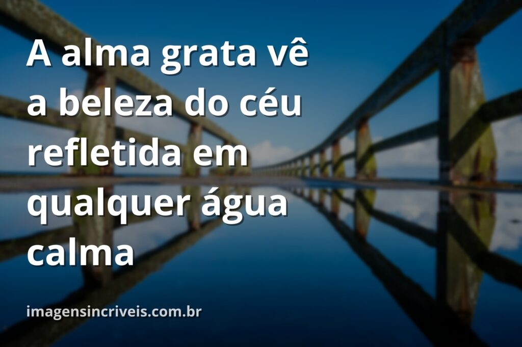 Céu azul com nuvens brancas refletido perfeitamente na superfície calma de um lago, cercado por natureza verdejante, transmitindo paz e gratidão.