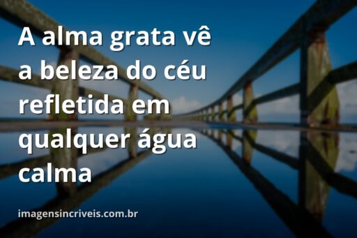 Céu azul com nuvens brancas refletido perfeitamente na superfície calma de um lago, cercado por natureza verdejante, transmitindo paz e gratidão.